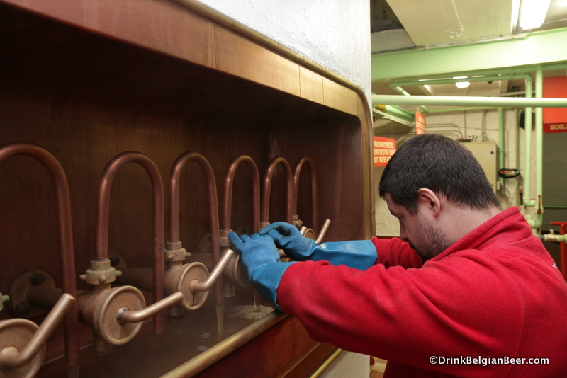 Dries Lemmens, a brewer at Timmermans, adjusting the filter taps at wort is pumped through them. 