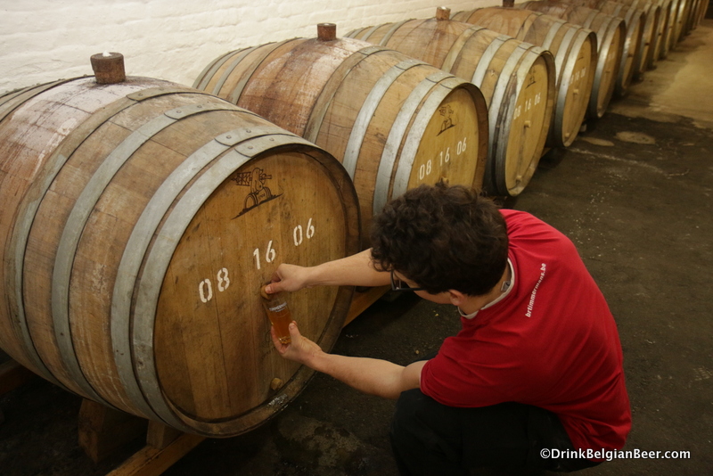 Brewer Kloris Deville pulling some lambic from a barrel. 