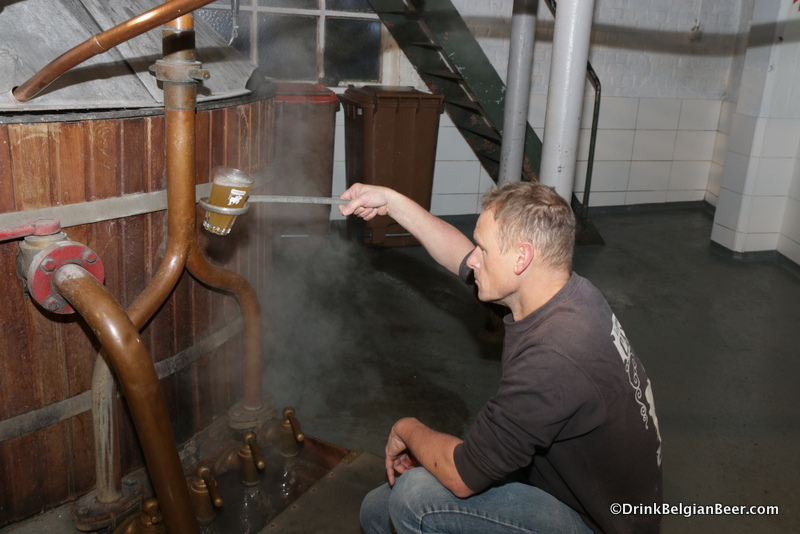 Brasserie Cantillon brewmaster Jean Van Roy checking the hot wort from the mash tun. 