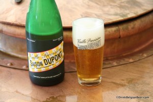 Photograph of bottle and glass of Brasserie Dupont Saison Dupont on copper brewkettle