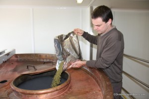 Photo of Dupont Brewmaster pouring hop pellets into boiling kettle