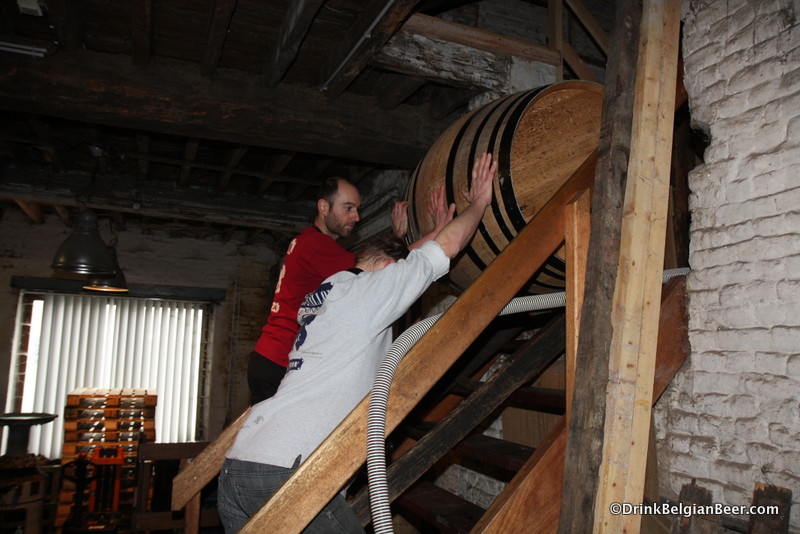 Jean Van Roy (right) brewmaster, and a worker lowering a barrel. Hands-on, hard work is the order of the day at Brasserie Cantillon.