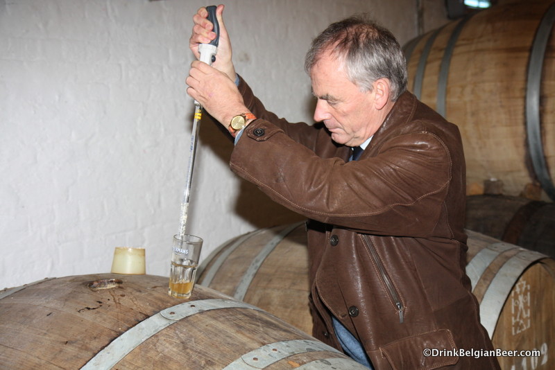 Willem Van Herreweghen of Timmermans pulling a sample of lambic from a barrel. 