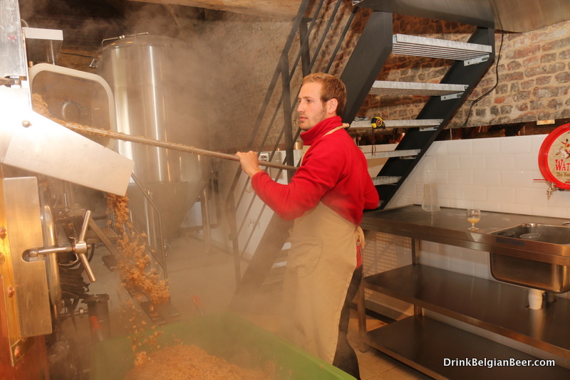 Anthony Martin's son, removing spent grains from the mash tun at Brasserie Waterloo. 