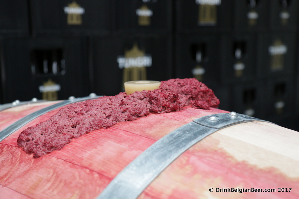 A barrel filled with raspberries undergoing a very active fermentation. 