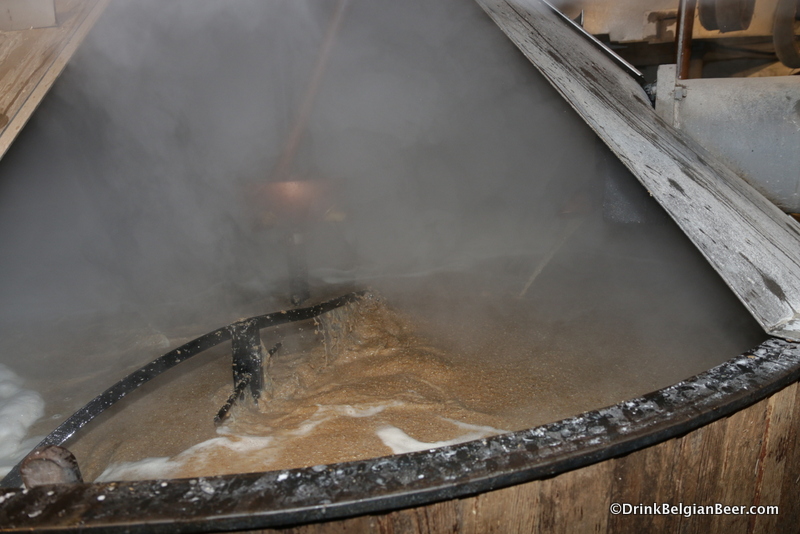 The mash tun at Brasserie Cantillon in action, with hot water being pumped in via a copper pipe on the right.