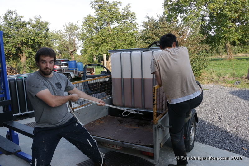 Raf Soef preparing to pull a container of fruit slush off a trailer at Stokerij Vanderlinden. 