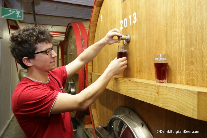 Brouwerij Timmermans brewer Kloris Deville pulling samples of kriekenlambiek from a foeder. 