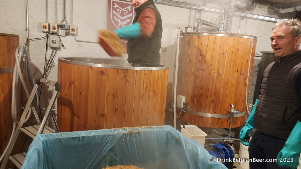 Another image of Robert Taymans shoveling spent grains out of the mash tun. Brother François Taymans is to the right. 